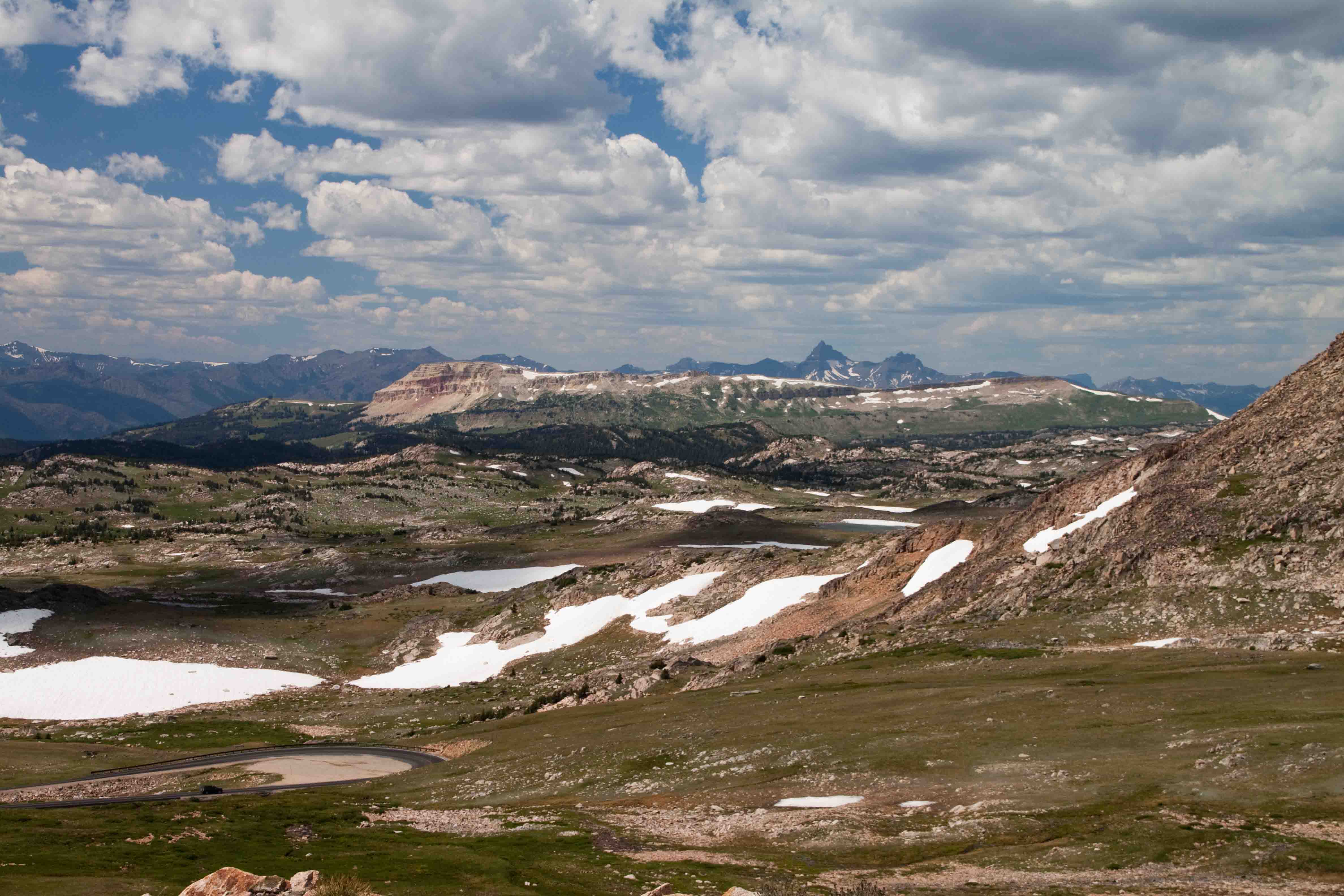 patches of snow and an expanse of mountain tops viewed from beartooth highway