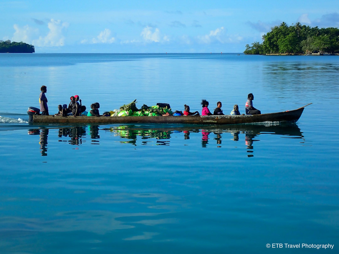 islanders in from munda in canoe with beautiful reflection